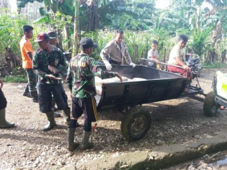 WARGA IKUT MEMBANTU TNI MENGANGKUT BAHAN MATERIAL