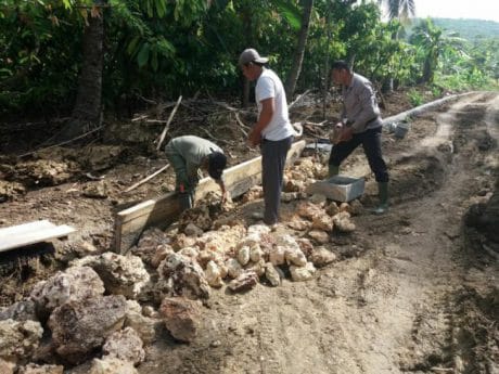 Prajurit TNI memikul Semen di Lokasi TMMD