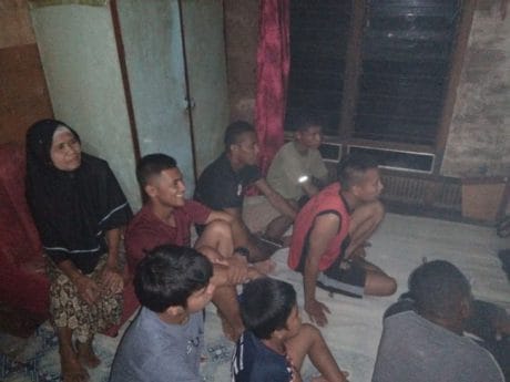 Anggota satgas TMMD nonton bareng dengan warga di malam hari