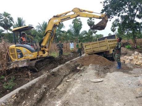 Sebuah mobil truk sedang membongkar muatan timbunan di lokasi TMMD