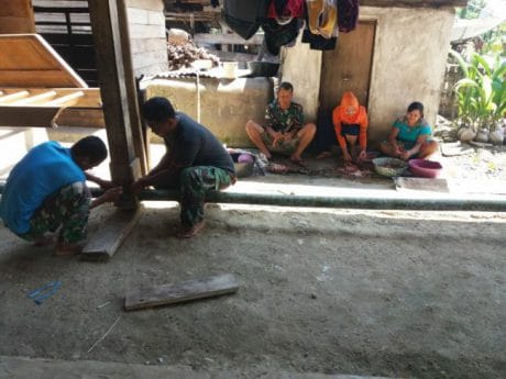 Melakukan pembersihan di sekitar rumah warga tempat posko TMMD