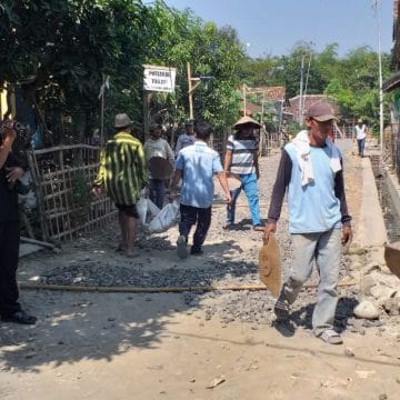 Warga Berjibaku Ratakan Material Jalan Makadam