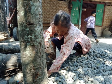 Saminah Bantu Satgas TMMD Kumpulkan Material Jalan