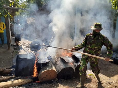 Satgas Pra TMMD Mengangkat Cairan Aspal Untuk Diratakan