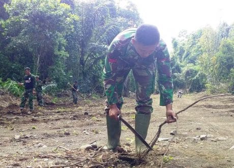SISA-SISA AKAR POHON DAN RANTING DI SEPANJANG JALAN BARU, DIBERSIHKAN ANGGOTA SATGAS TMMD