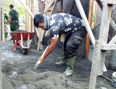 ANGGOTA SATGAS TAMPAK BERSEMANGAT MENGADUK SEMEN