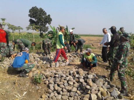 TNI dan Warga Gotong royong Bangun Jalan Makadam