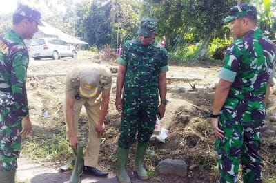 SEBELUM MENINJAU LOKASI PENGERJAAN TMMD KE-105, DANSATGAS BERIKAN SEPATU BOOT KEPADA LURAH DUASUDARA