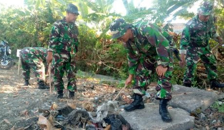 Tampak, puluhan anggota satgas terlihat membersihkan rumput