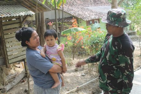 Disela Kesibukan TMMD, Anggota Satgas Ajak Seorang Ibu Ikut Posyandu