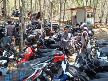 Tukang Parkir Memberikan Karcis Kepada Pemilik Motor