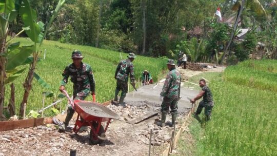 Berjalan Mundur, Anggota Satgas TMMD ke 106 Usung Material ke Sasaran Rabat Jalan