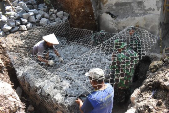 Kegembiraan Satgas TMMD Bersama Warga Memasang Kawat Bronjong Sambil Bernyanyi