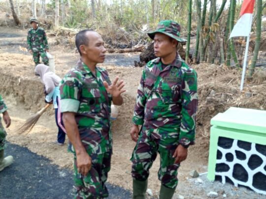 Satgas TMMD Bersihkan Lokasi Jalan Makadam Dari Tanah Yang menempel Di Aspal
