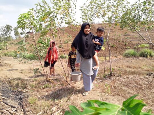 Gendong Anak Sambil Membawa Pasir Di Ember, Wujud Kepedulian Istri Kaur Pemerintahan Cilibang