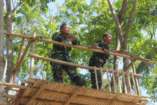 Orientasi Medan, Dua Satgas TMMD Berdiri Diatas Gasebo Di Atas Kolam