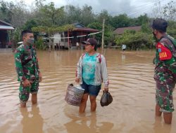 Prajurit TNI dan relawan membantu proses evakuasi korban banjir