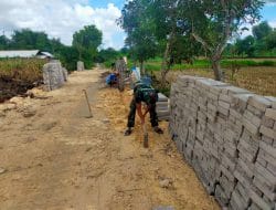 Anggota Satgas TMMD Ratakan Tanah Dengan Cangkul