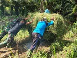 Anggota Satgas TMMD Bantu Warga Dorong Motor