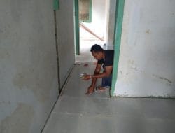 Anggota satgas TMMD hampir selesai kan pembangunan Puskesmas pembantu dengan pemasangan Nat pustu keramik