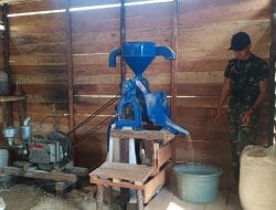 Anggota satgas TMMD membantu warga menggiling padi