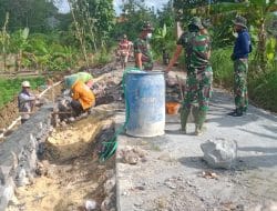 Semangat Satgas TMMD Dengan Gerobak Dorong Untuk Pengecoran Jalan