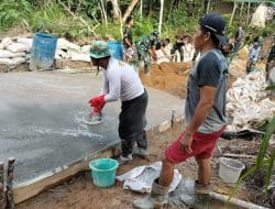 Anggota Satgas TMMD Mengaci Jalan Rabat Beton