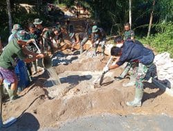 Anggota TMMD satgas terus pacu Semanggat saat mengadon semen bersama warga