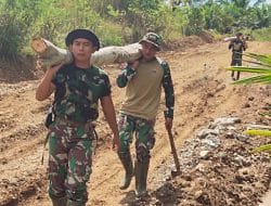 Prajurit TNI Panggul Kayu Untuk Pemasangan Siring