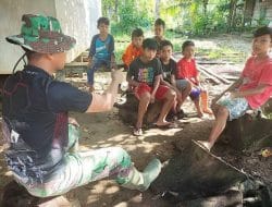 Anggota satgas TMMD bercengkrama dan bercerita bersama