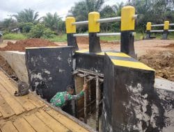 Anggota satgas TMMD Ke 111 kodim 1202/Singkawang Membersihkan Kayu Penyangga Jembatan