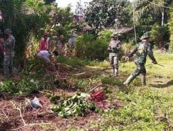 Anggota satgas TMMD kerja bakti bersama masyarakat desa dalam pembersihan lingkungan