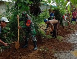 Anggota satgas TMMD membuat parit di pinggiran jalan