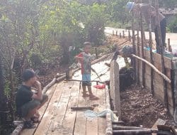 Anak anak desa bermain di jembatan darurat yang di buat anggota satgas TMMD