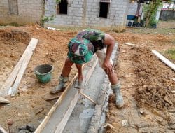 Anggota satgas TMMD plaster parit puskesmas pembantu yang telah di buat