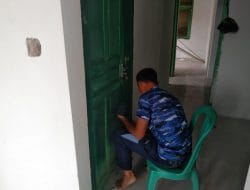 Anggota satgas TMMD mengecat pintu kamar puskesmas pembantu.