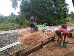 Warga dan Anggota Satgas TMMD Ke-111 Memasang Papan Mal Jalan Rabat beton