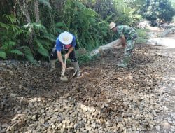 Kades Sentangau Jaya Bantu Perataan Batu Kerikil Jalan Rabat Beton Satgas TMMD Ke-111 Kodim 1202/Singkawang