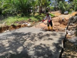 Anggota satgas TMMD melakukan penaburan semen untuk lapis atas jalan rambat beton