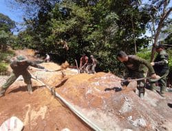 Anggota Satgas TMMD Mengaduk Semen Untuk Jalan Rabat Beton