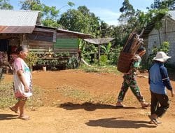 Anggota Satgas TMMD Regtas Ke 111 Kodim 1202/Skw Bantu Warga Pikul Kayu Bakar