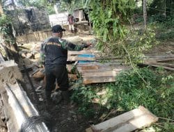 Anggota Satgas TMMD Membersihkan Area Di Sekitar Lokasi