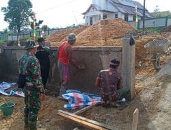 Anggota Satgas Memasang Batako Pembangunan Pagar Pustu