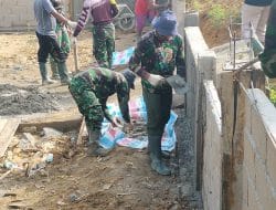 Anggota Satgas TMMD mulai mempemplaster pagar puskesmas pembantu