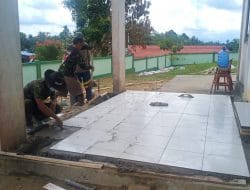 Anggota Satgas Pasang Keramik Di Lantai Gereja