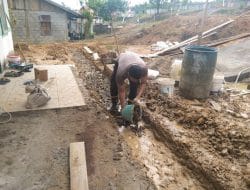 Anggota satgas TMMD tabur batu kerikil untuk pondasi pembuatan pagar puskesmas pembantu