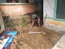Anggota satgas TMMD menggali parit pndasi pagar puskesmas menggunakan cangkul