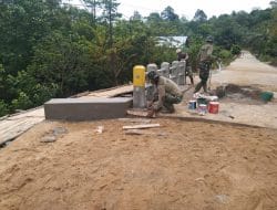 Anggota satgas TMMD plaster tepian jembatan beton yang selesai di bangun