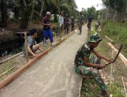 Warga dan Anggota Satgas TMMD Ke-111 Memasang Papan Mal