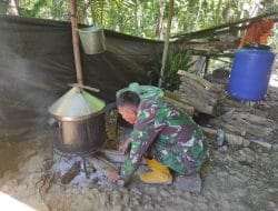 Anggota satgas TMMD memasak dengan cara tradisional menghilangkan kayu bakar